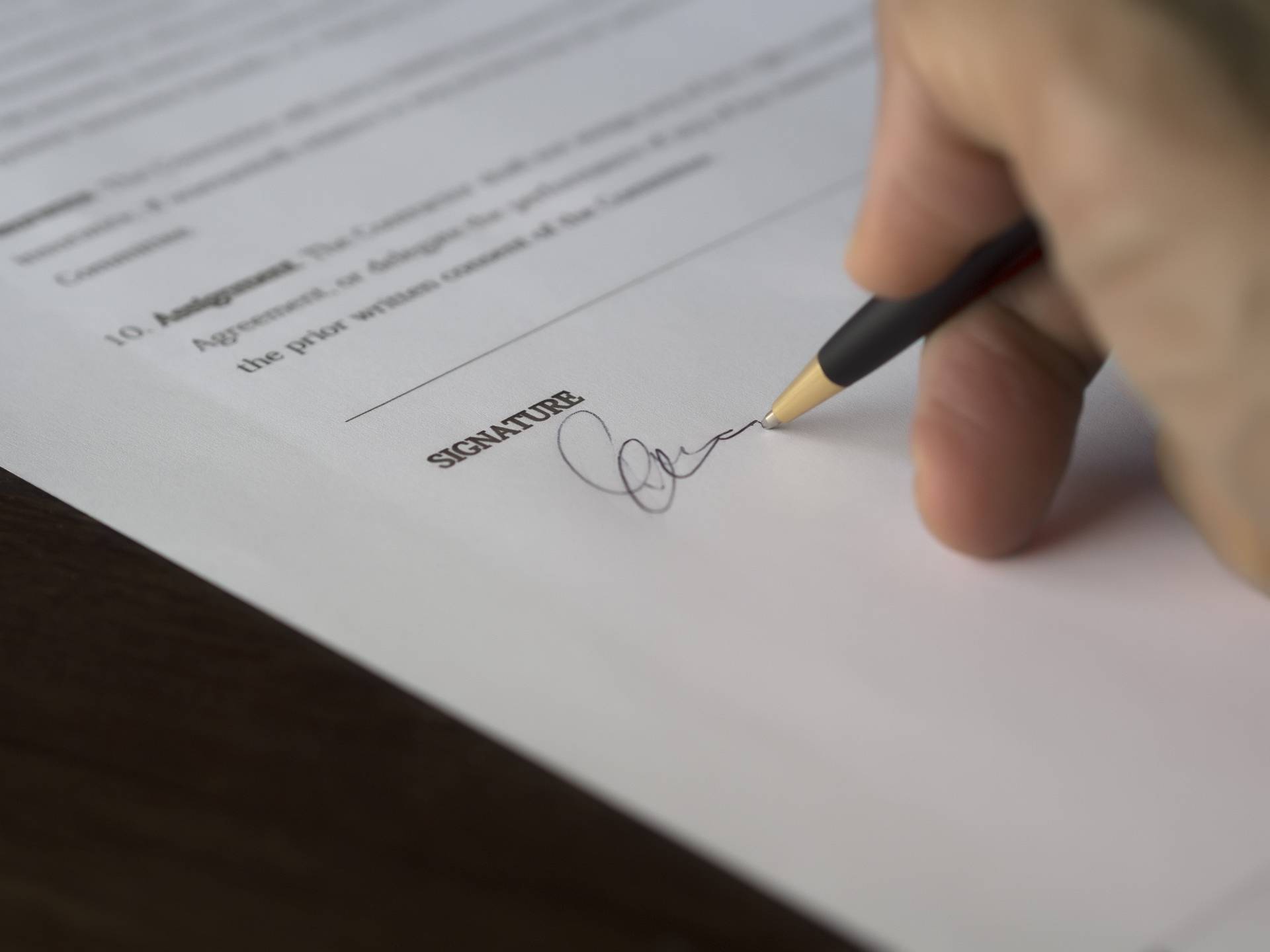Photograph of a signature being written on a formal document