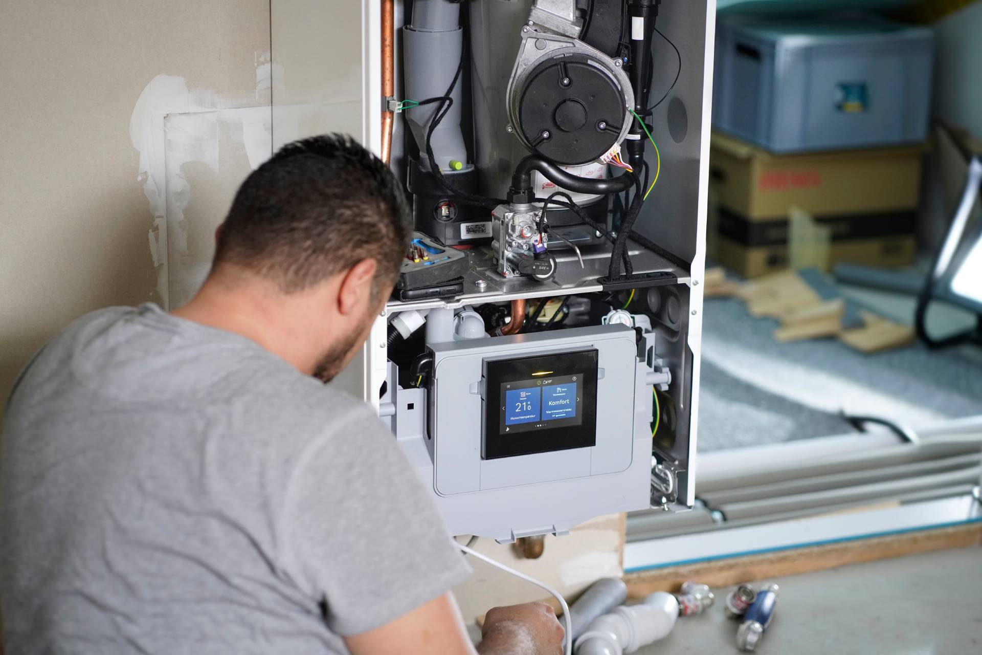 Photograph of a tradesman working on a boiler