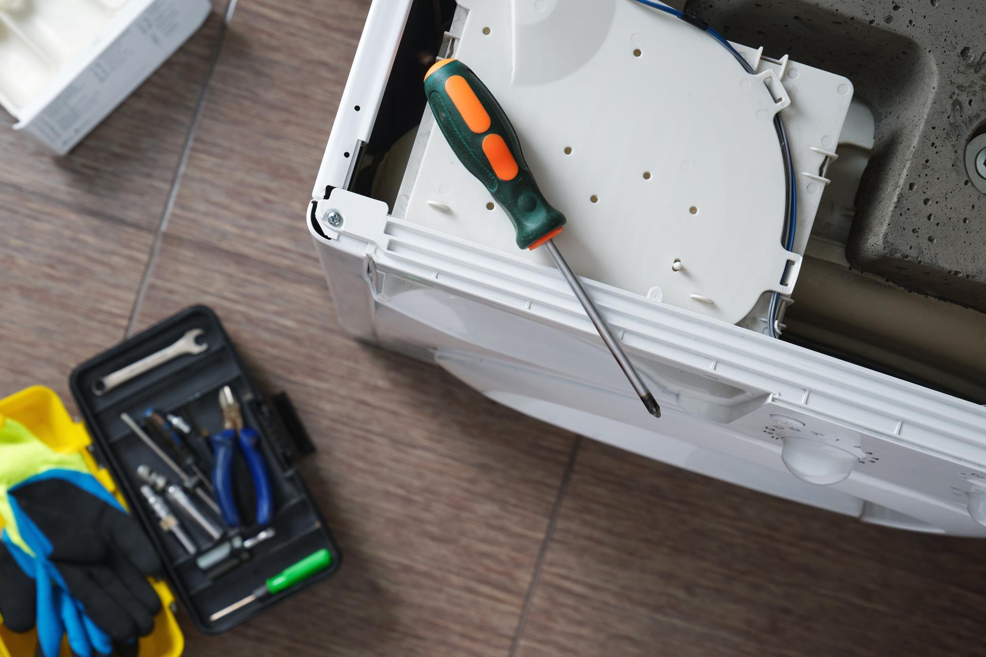 Photograph of tools being used to fix a washing machine